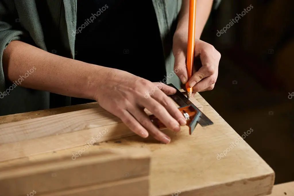 Contractor carefully measuring and cutting lumber